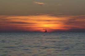 Asverstrooiing op zee - as-uitstrooien-op-het-water_ondergaanden-zon-met-bootje